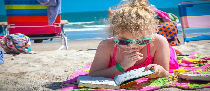 child reading on beach
